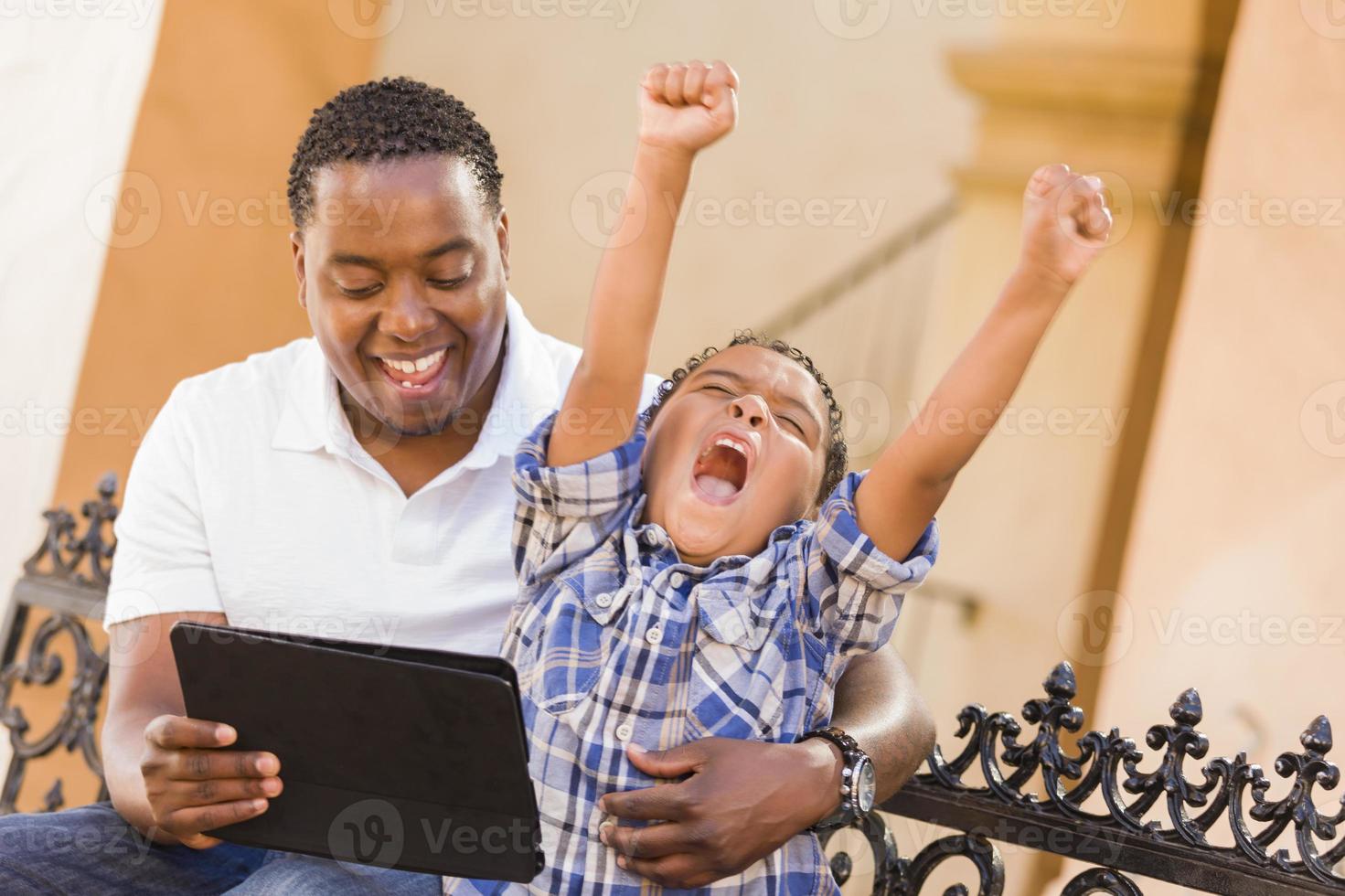 Mixed Race Father and Son Using Touch Pad Computer Tablet photo