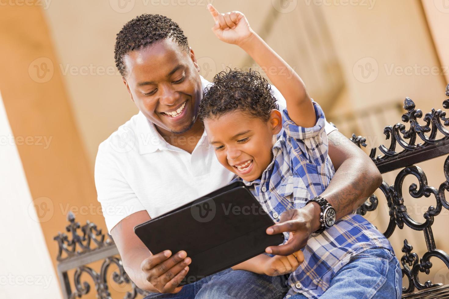 Mixed Race Father and Son Using Touch Pad Computer Tablet photo