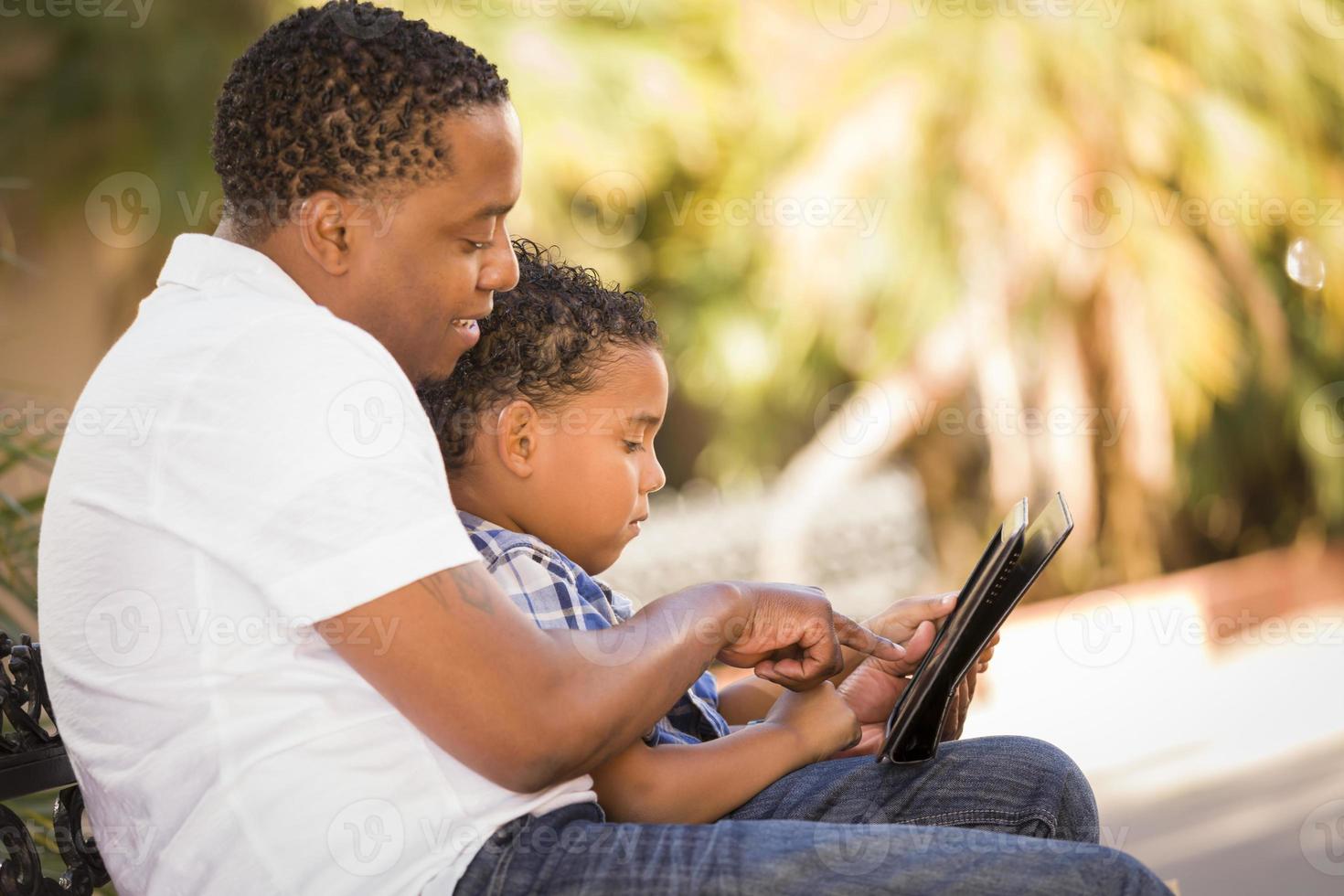Mixed Race Father and Son Using Touch Pad Computer Tablet photo