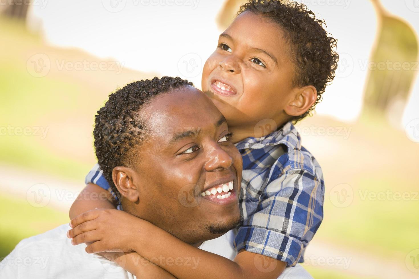 padre e hijo de raza mixta jugando piggyback en el parque foto