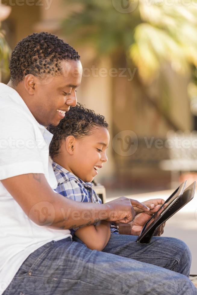 Mixed Race Father and Son Using Touch Pad Computer Tablet photo