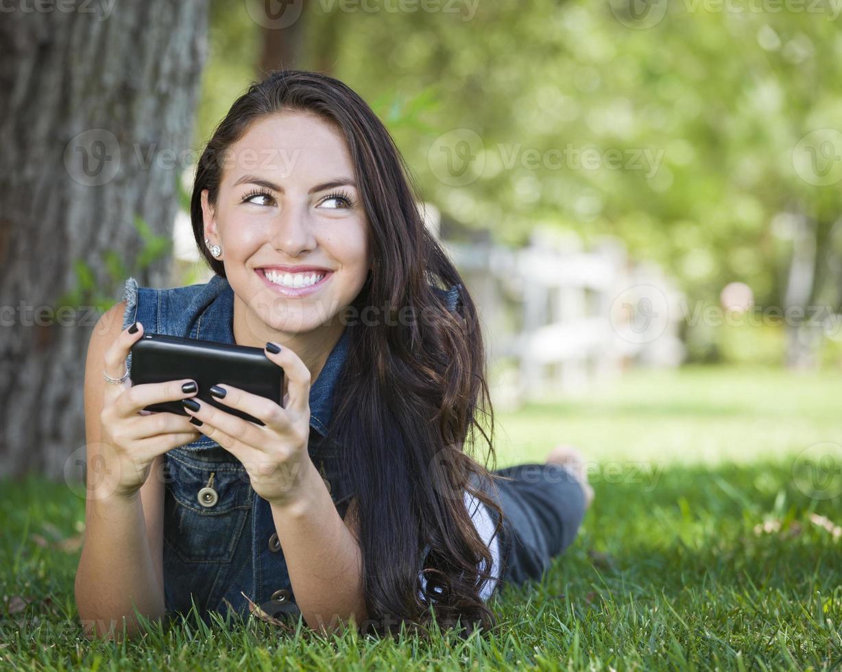 Mixed Race Young Female Texting on Cell Phone Outside photo