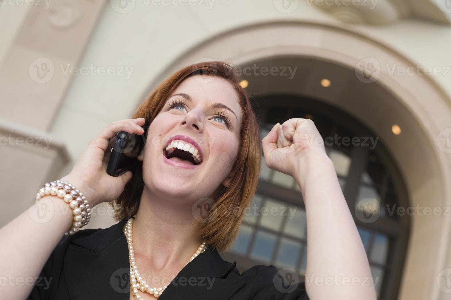 Young Businesswoman with Fist in Air On Cell Phone photo