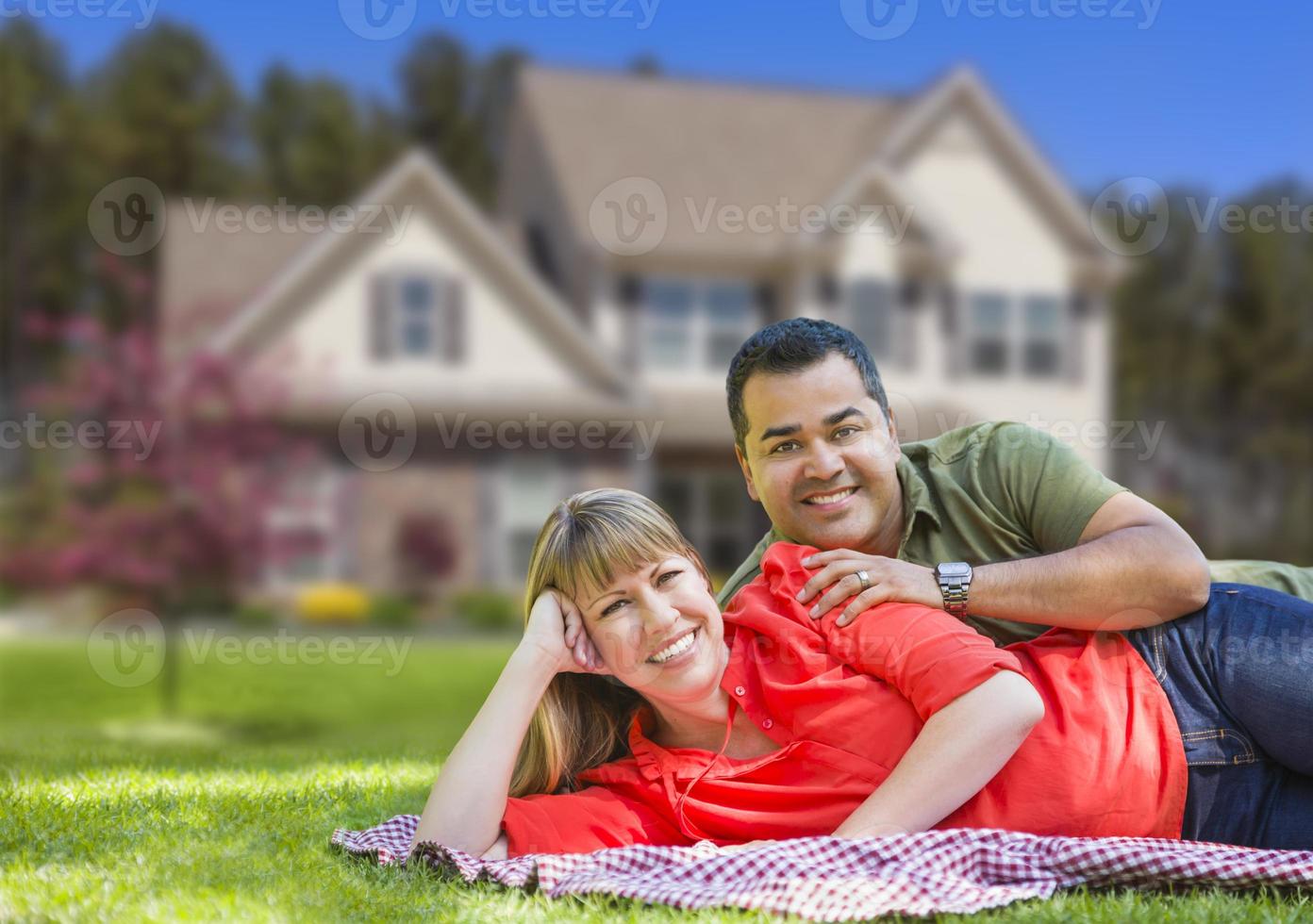 feliz pareja de raza mixta en frente de la casa foto