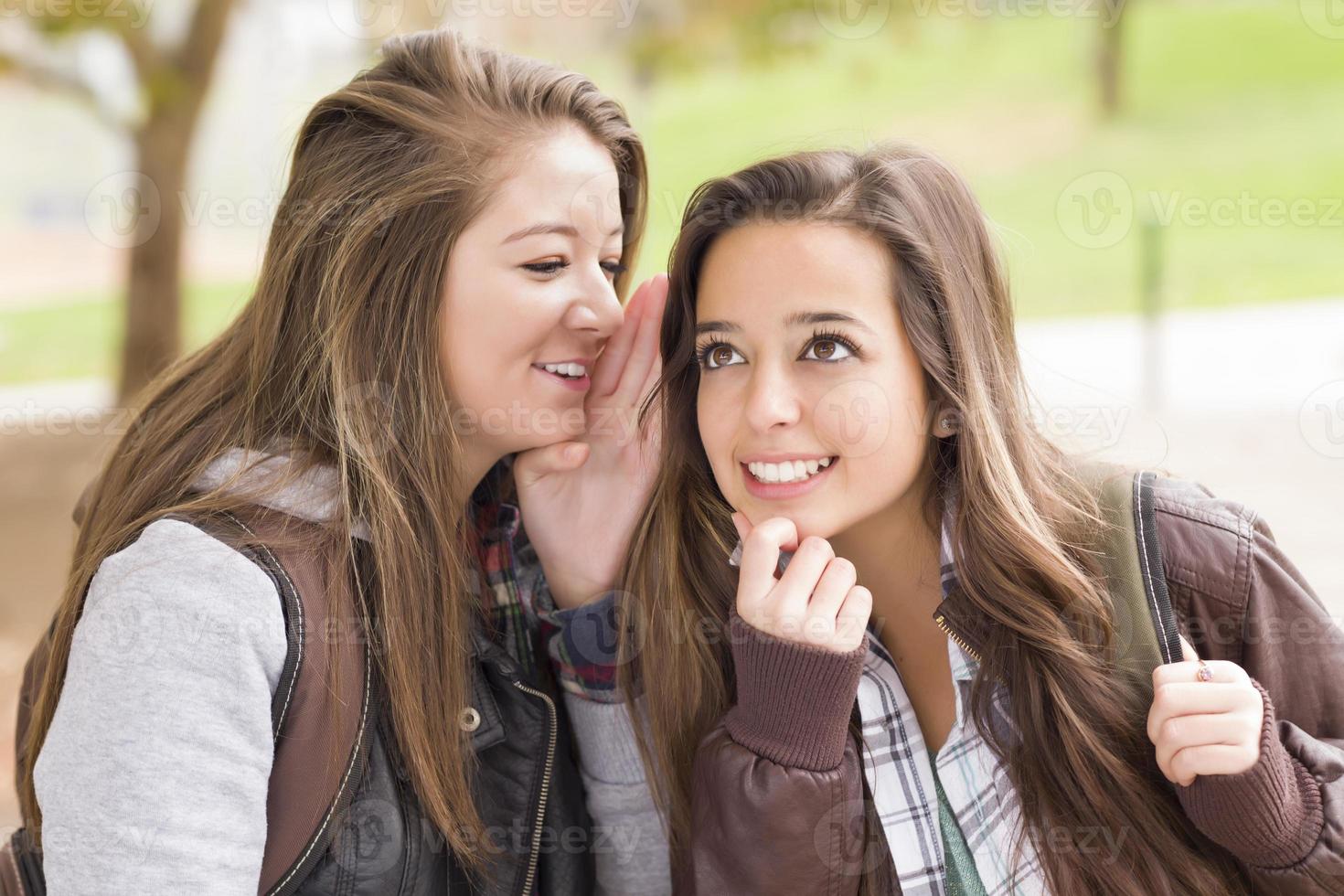 Mixed Race Woman Whispering Secrets Outside photo