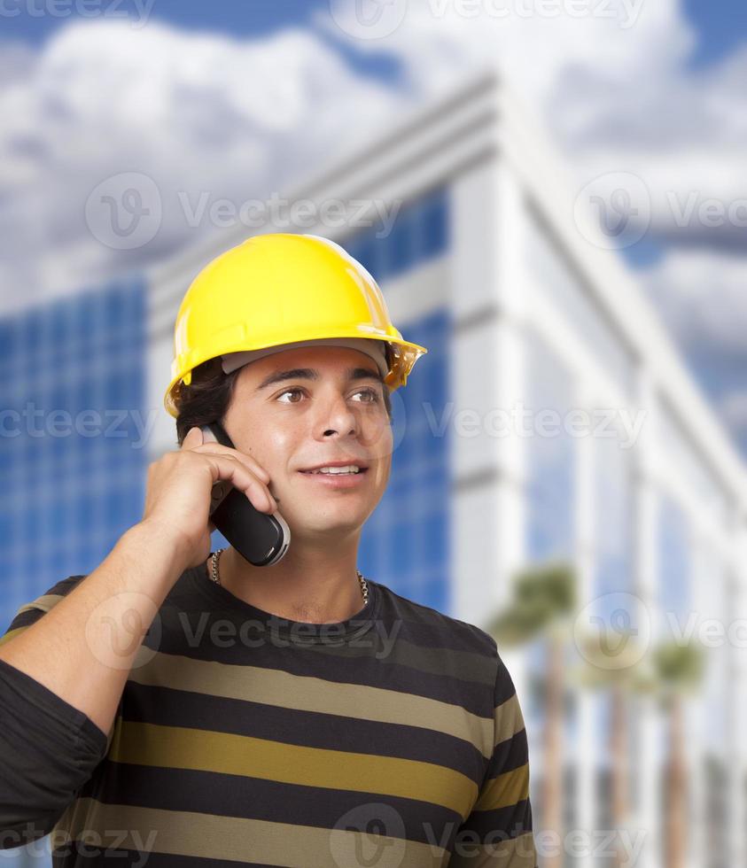 Hispanic Male Contractor on Phone in Front of Building photo