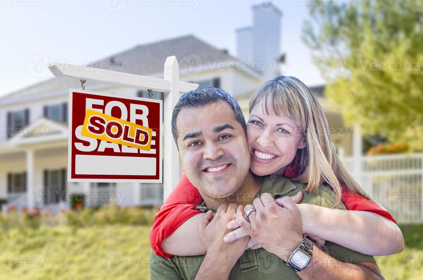 Couple in Front of Sold Real Estate Sign and House photo