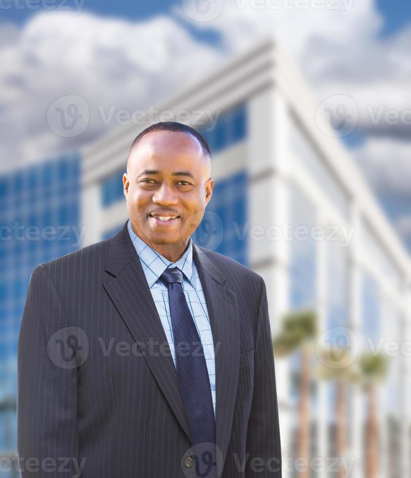 apuesto hombre de negocios afroamericano frente al edificio corporativo. foto