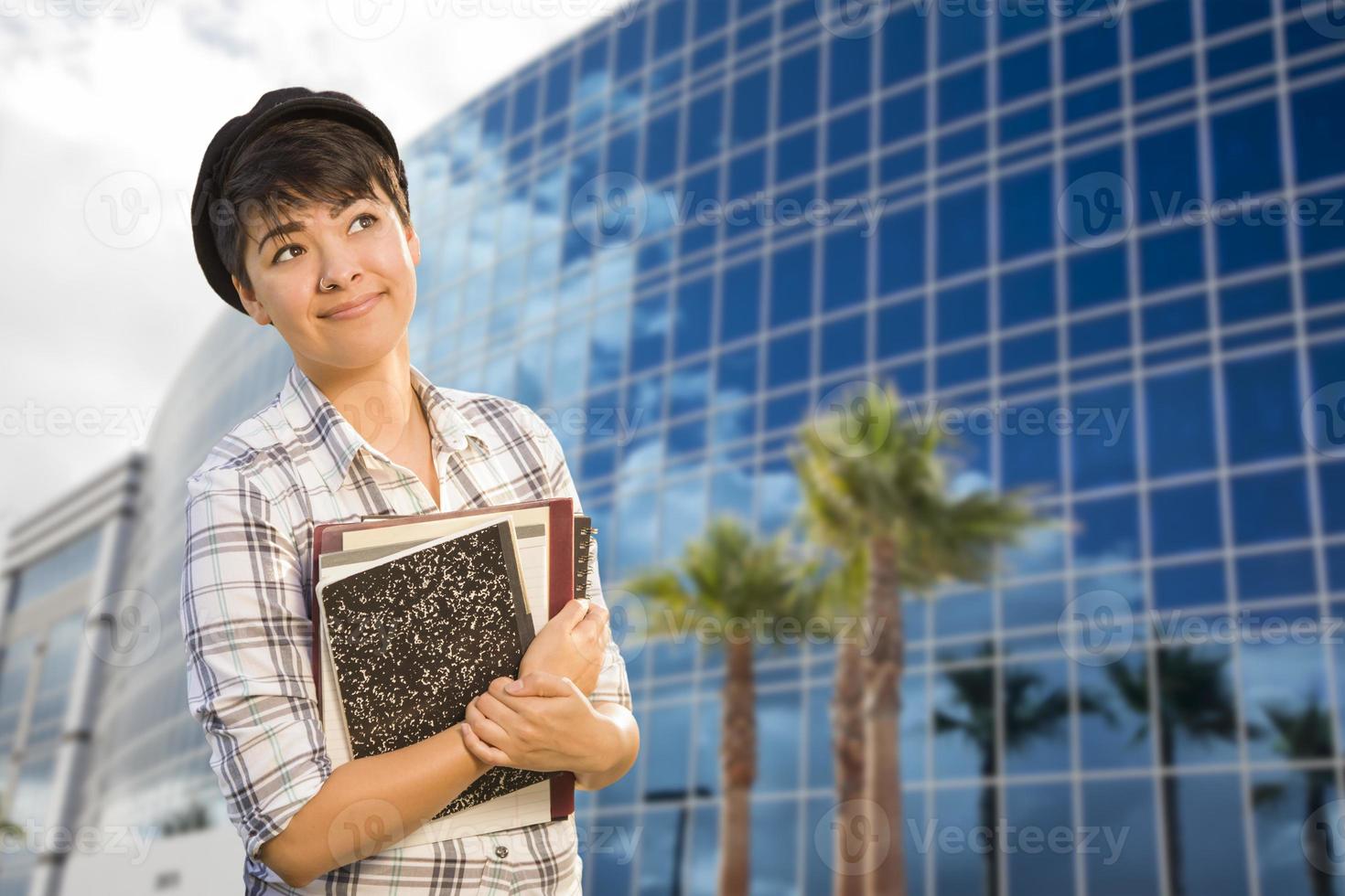 Mixed Race Female Student Holding Books in Front of Building photo