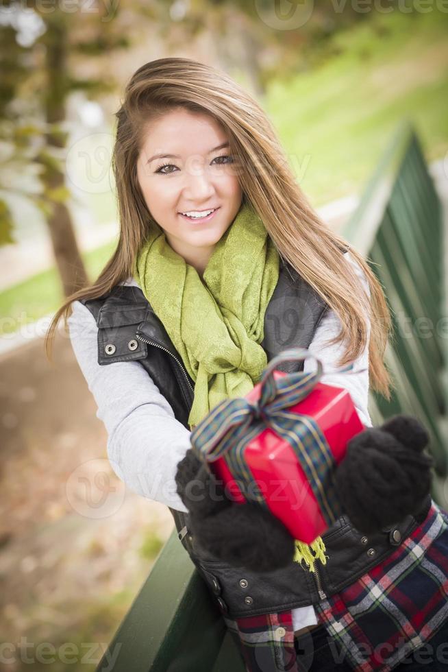 Pretty Woman with Wrapped Gift with Bow Outside photo