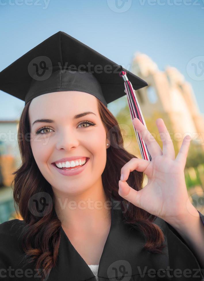 feliz graduarse mujer de raza mixta en toga y birrete foto