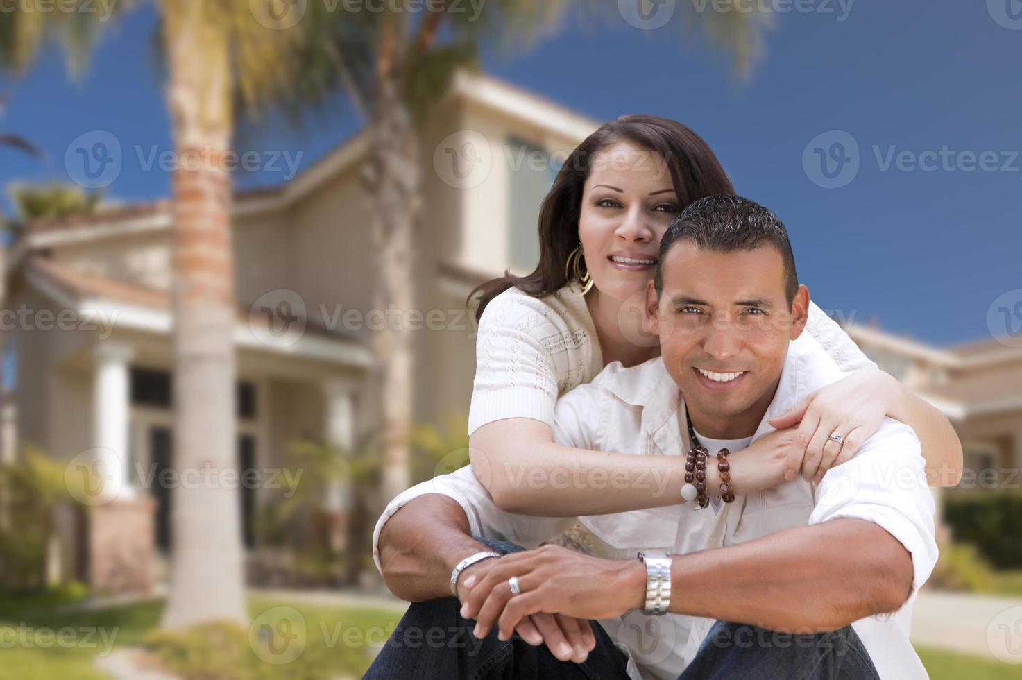 Happy Hispanic Young Couple in Front of Their New Home photo