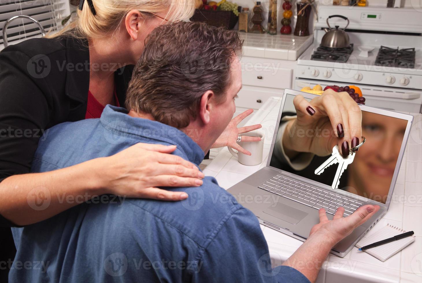Couple In Kitchen Using Laptop - House Keys photo