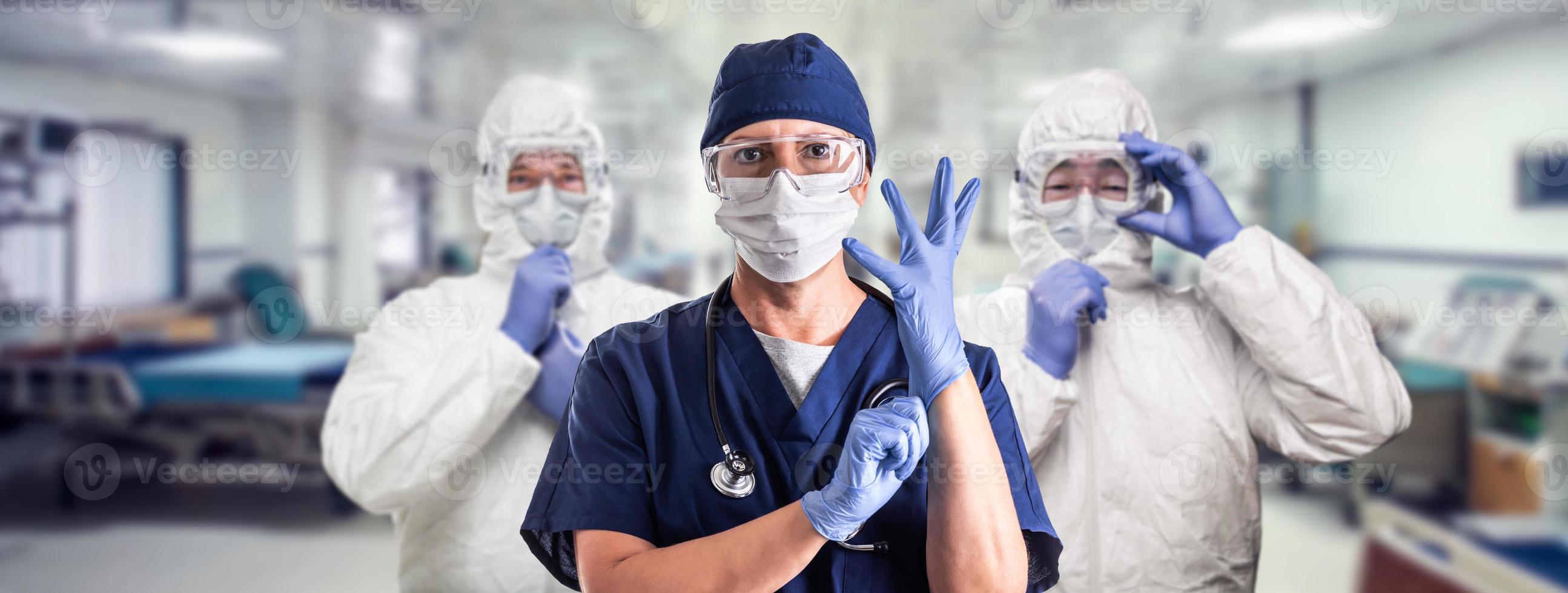 equipo de médicos o enfermeras mujeres y hombres que usan equipo de protección personal en la sala de emergencias del hospital. foto