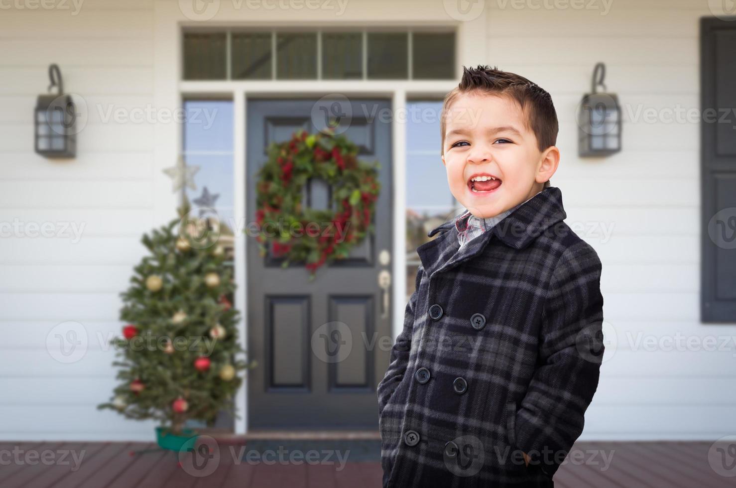 Young Mixed Race Boy On Front Porch of House with Christmas Decorations photo