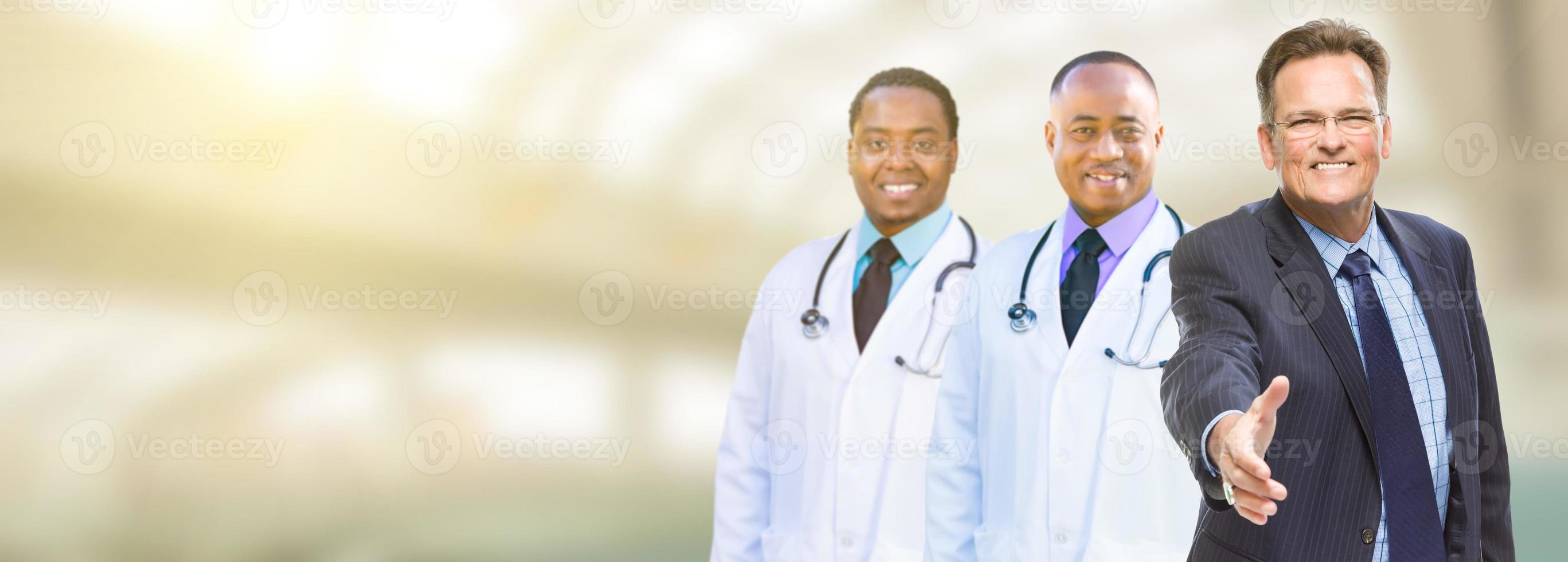 hombre de negocios caucásico y médicos, enfermeras o farmacéuticos afroamericanos con espacio para texto. foto