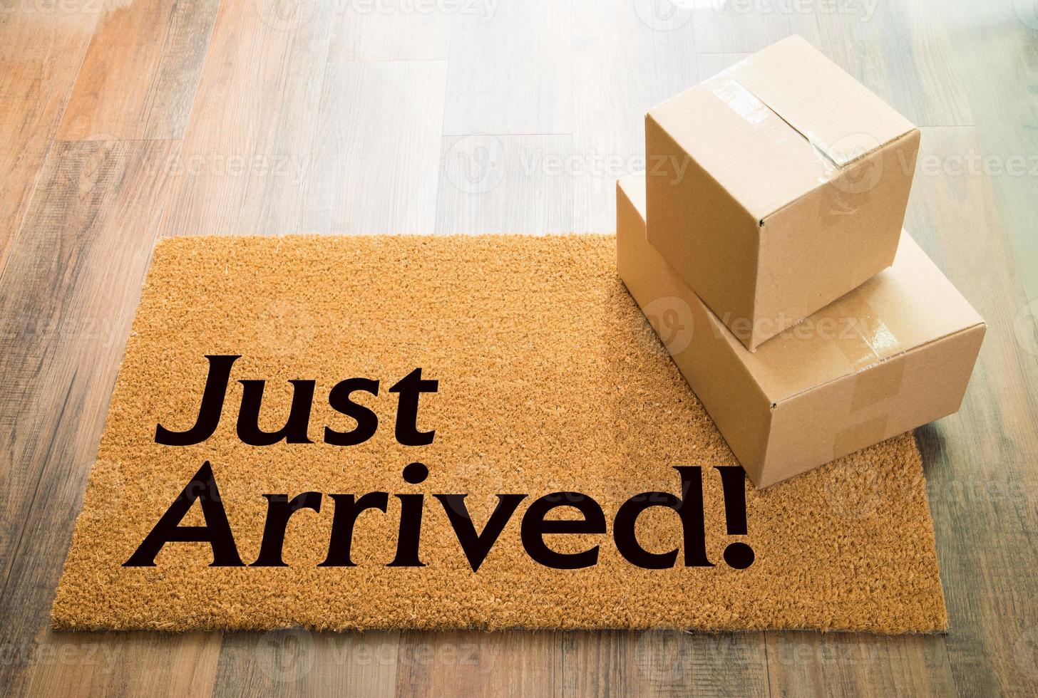 Just Arrived Welcome Mat On Wood Floor With Shipment of Boxes photo