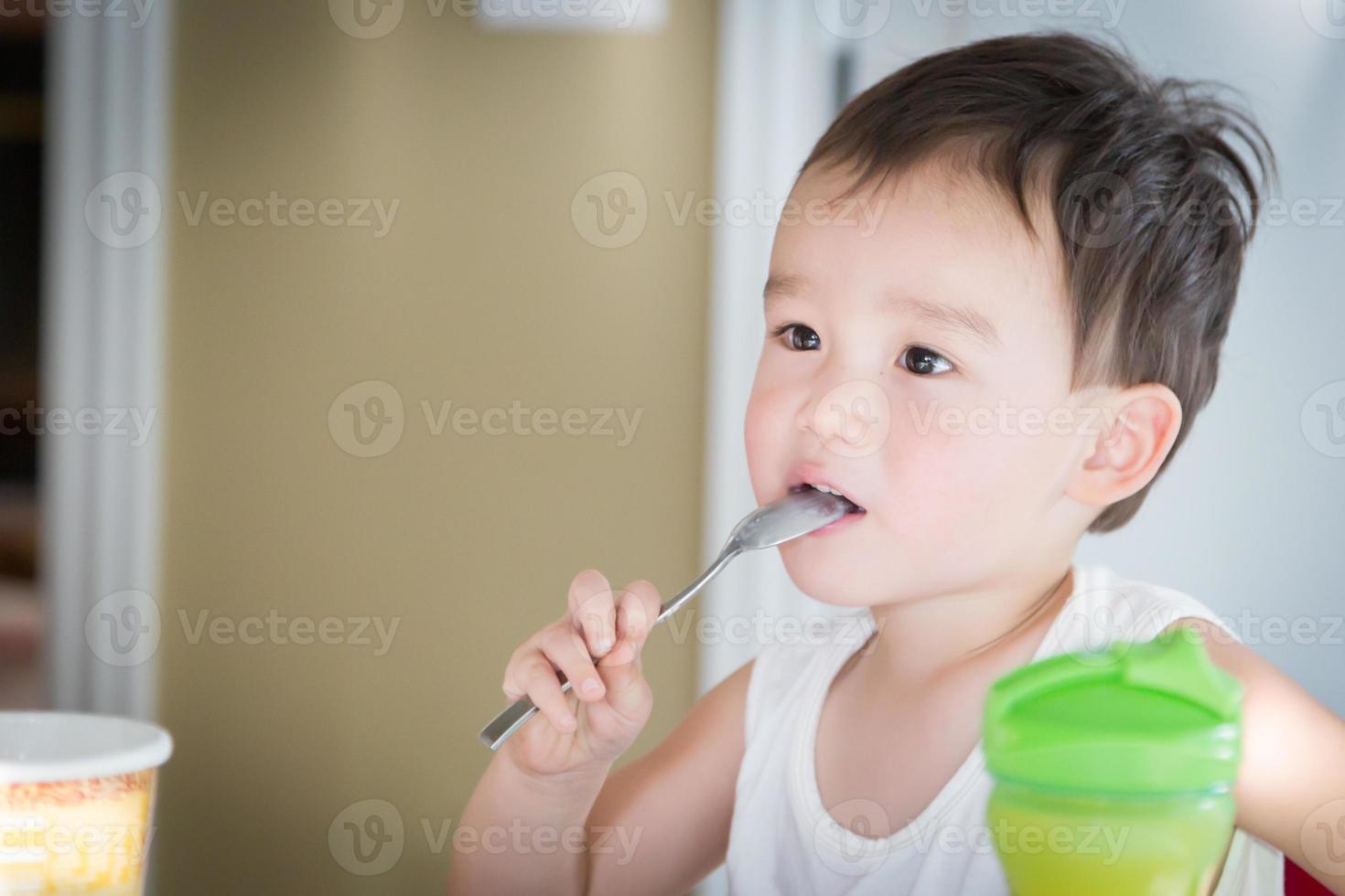 Cute Young Chinese and Caucasian Boy Enjoying Eating His Ice Cream photo