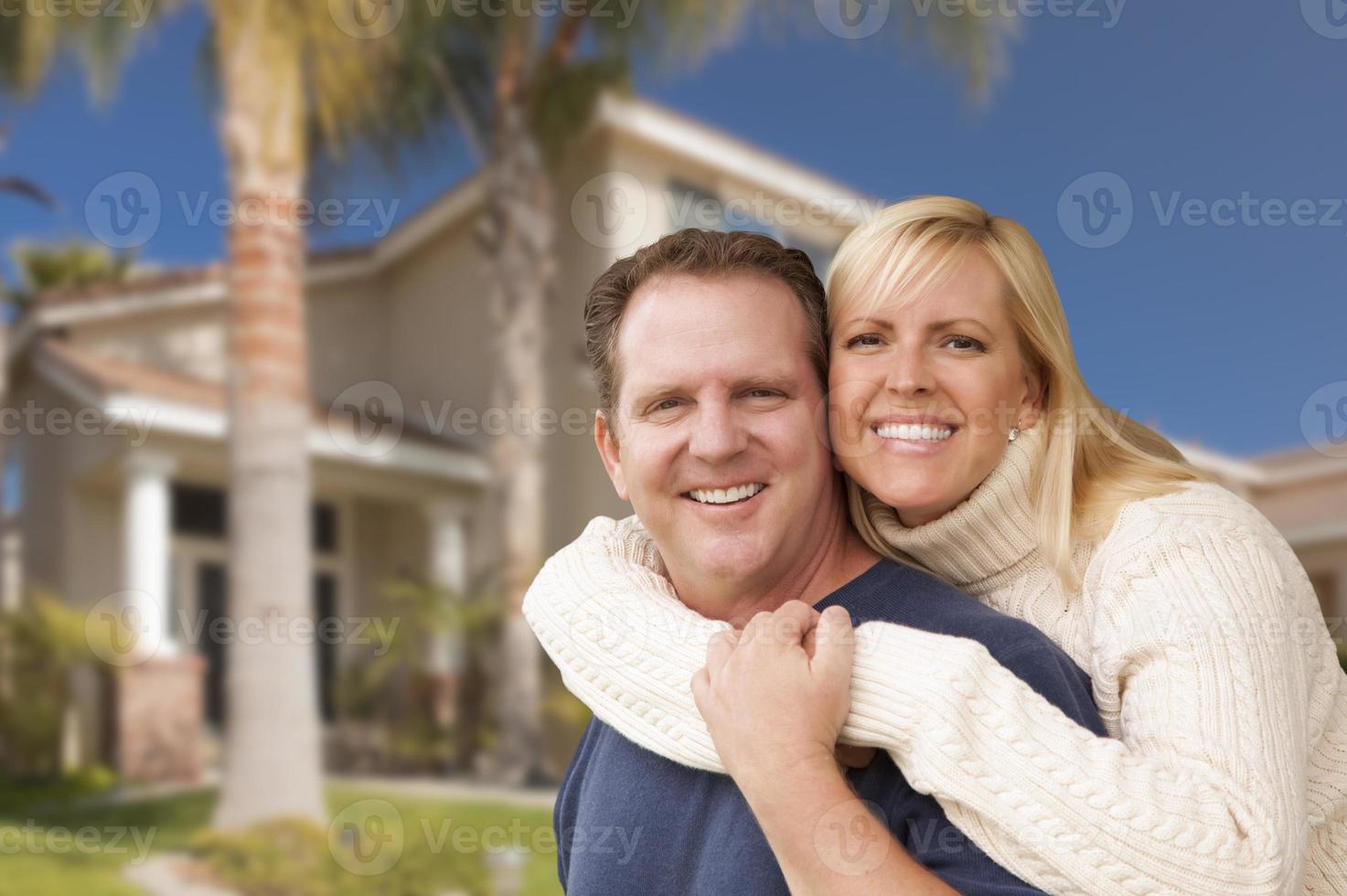 feliz pareja abrazándose frente a casa foto