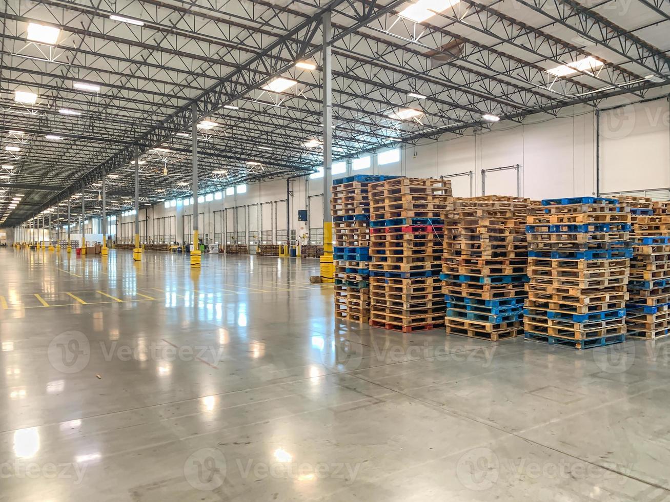 Massive Empty Industrial Warehouse Interior With Stacked Pallets photo