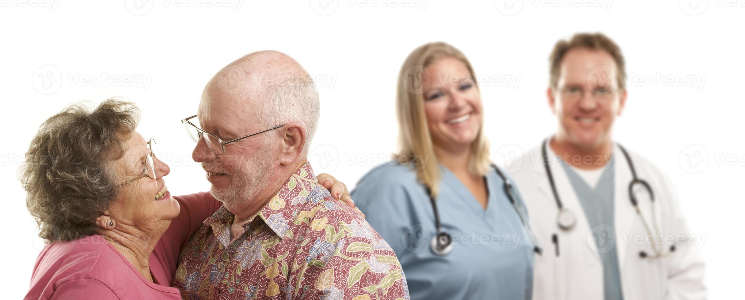 Senior Couple with Medical Doctors or Nurses Behind photo