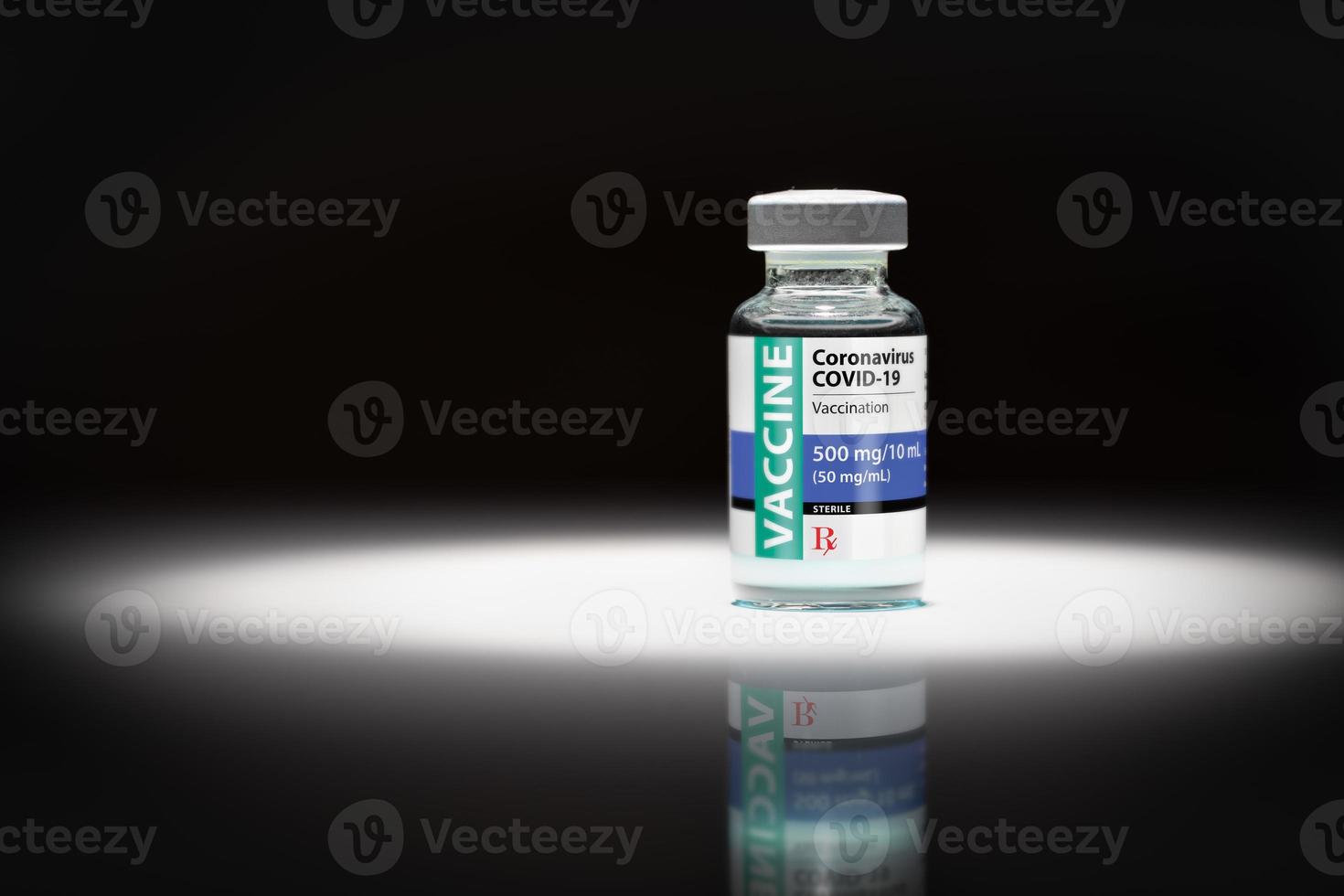 Coronavirus COVID-19 Vaccine Vial Spot Lit on Reflective Surface photo
