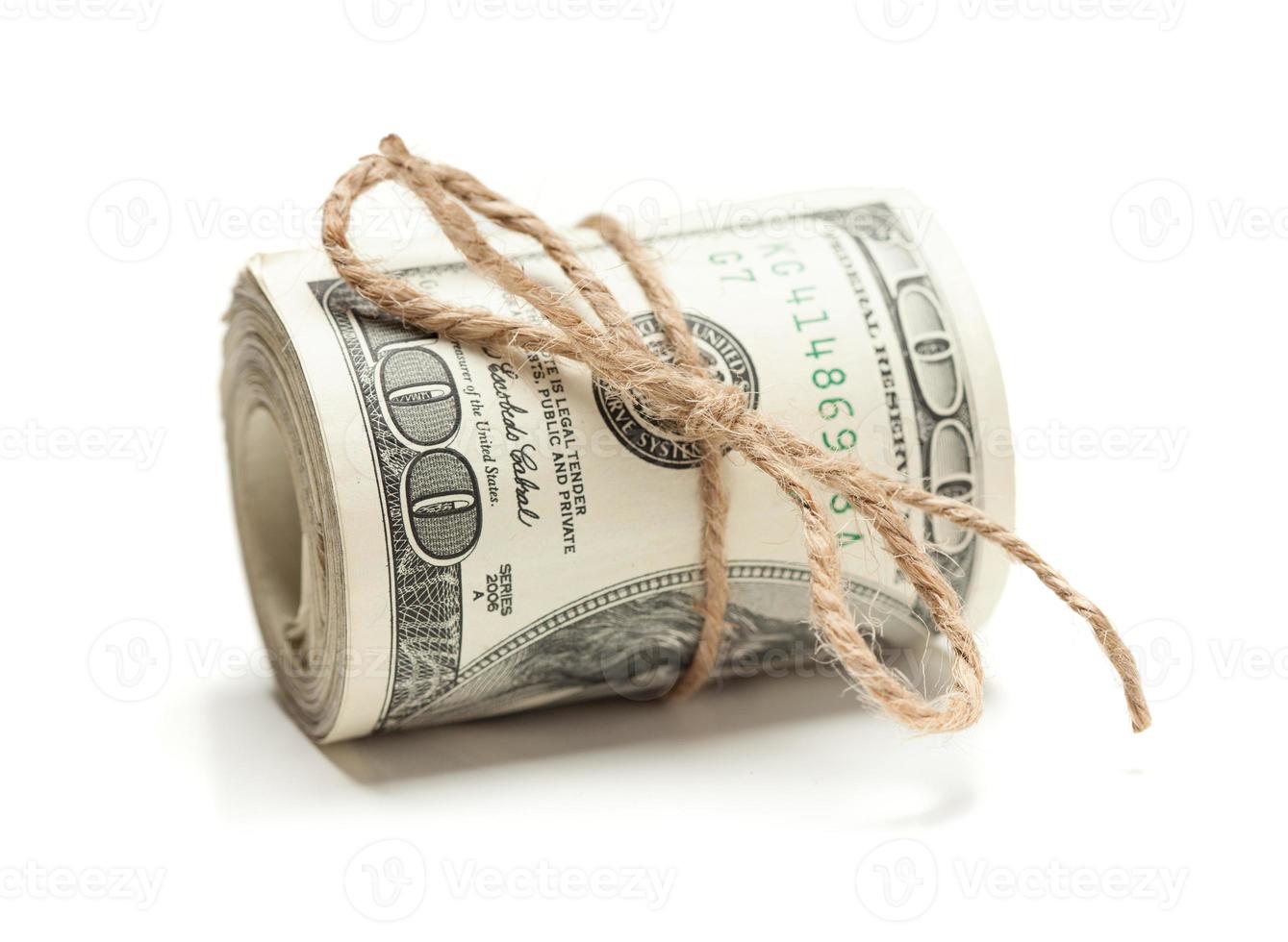 rollo de billetes de cien dólares atados en una cuerda de arpillera en blanco foto