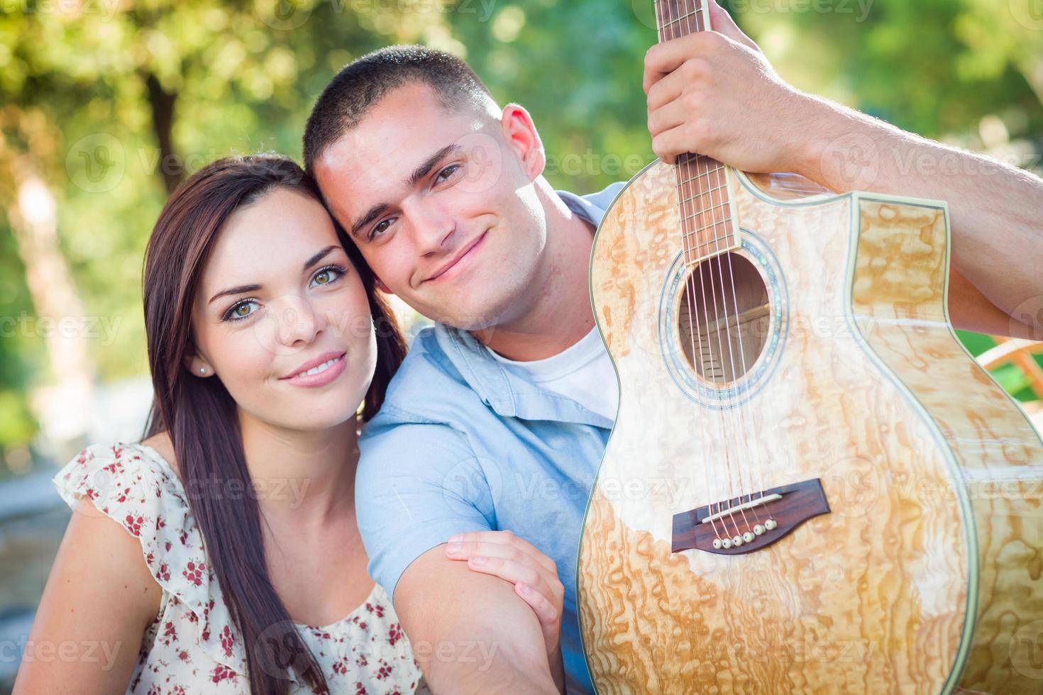 Young Adult Couple Portrait with Guitar in the Park. photo