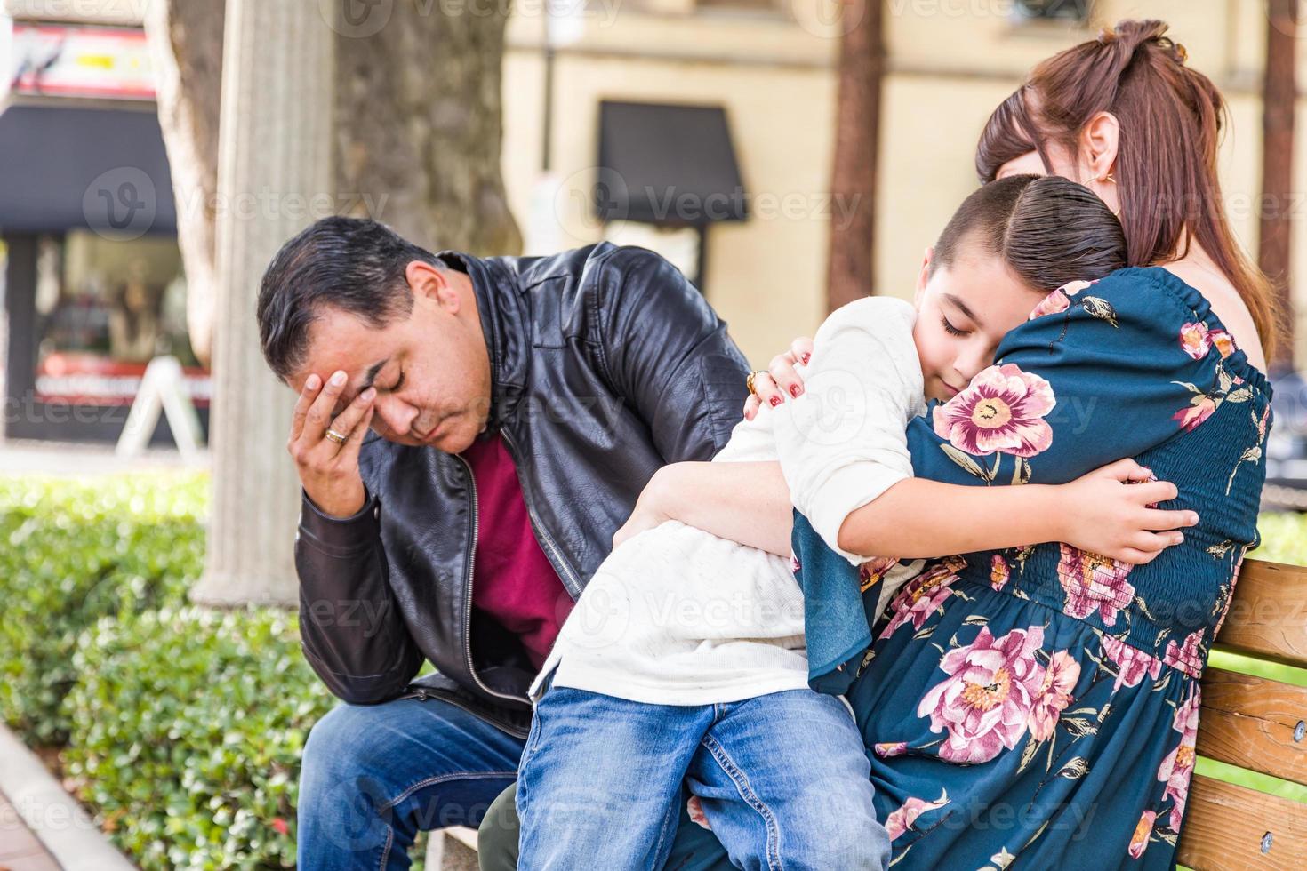 Caucasian Mother and Hispanic Father Comforting Mixed Race Son Outdoors photo