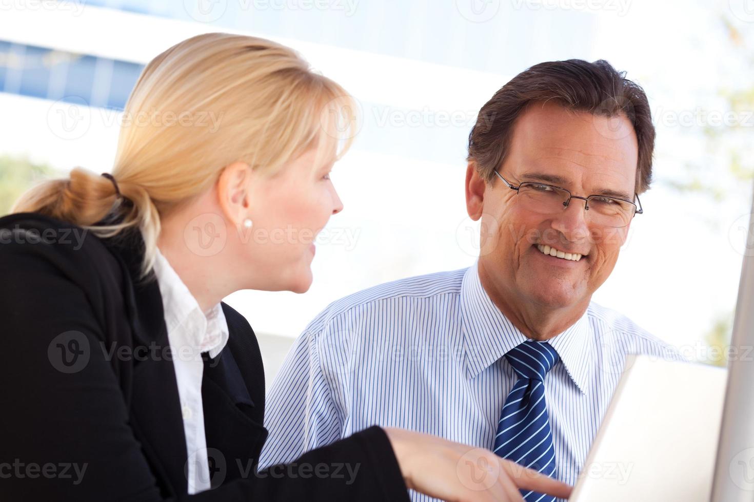Businessman and Female Colleague Using Loptop Outdoors photo