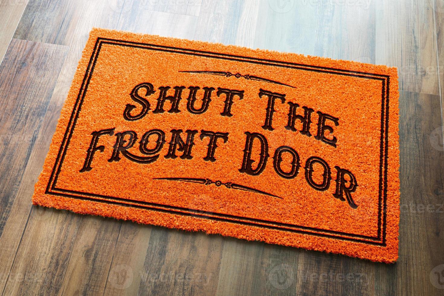 Shut The Front Door Halloween Orange Welcome Mat On Wood Floor Background photo