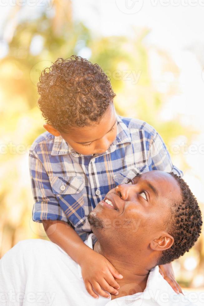 hijo de raza mixta y padre afroamericano jugando juntos al aire libre. foto