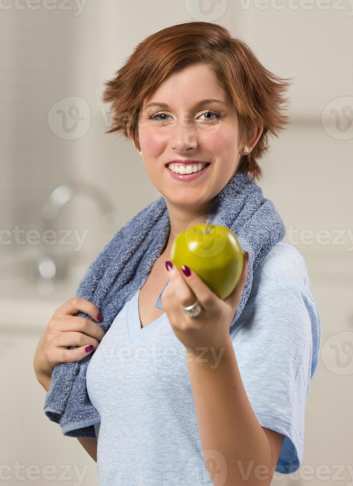 Pretty Red Haired Woman with Towel Holding Green Apple photo