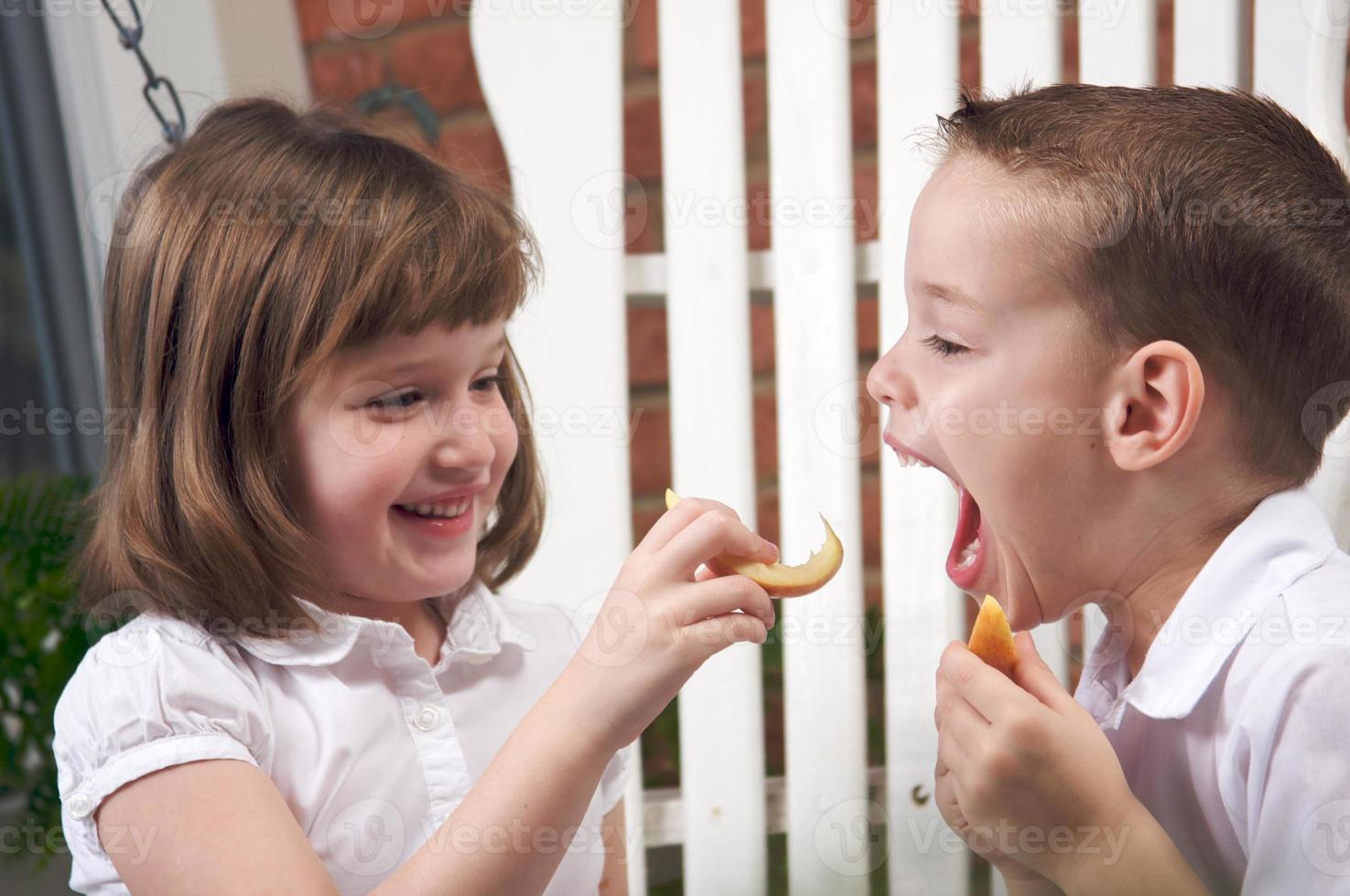 hermana y hermano comiendo una manzana foto