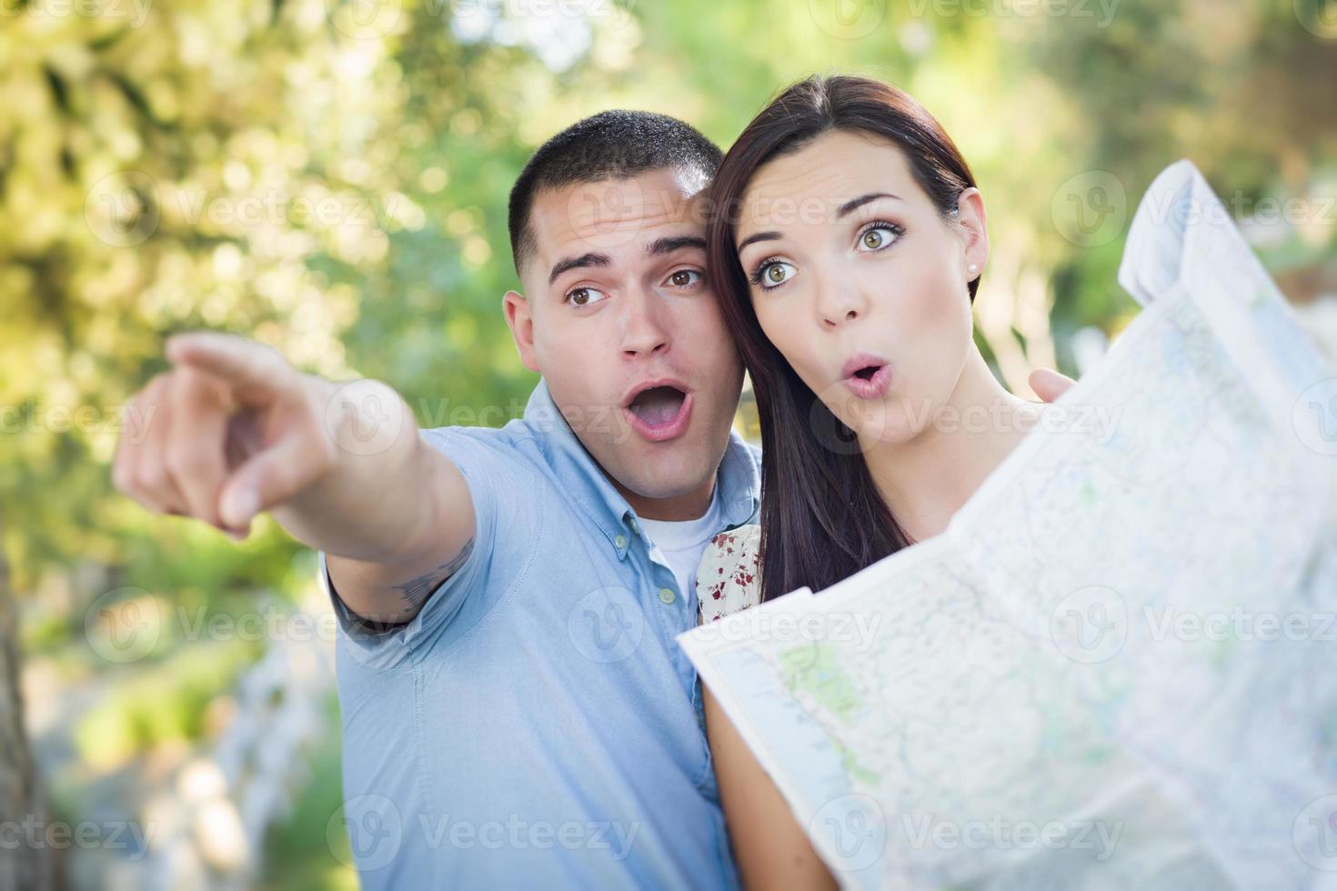 Mixed Race Couple Looking Over Map Outside Together photo