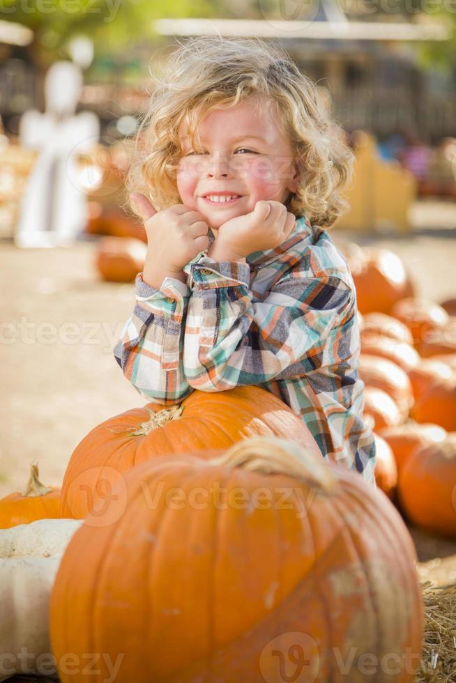 Little Boy Standing in a Rustic Ranch Setting at the Pumpkin Patch. photo