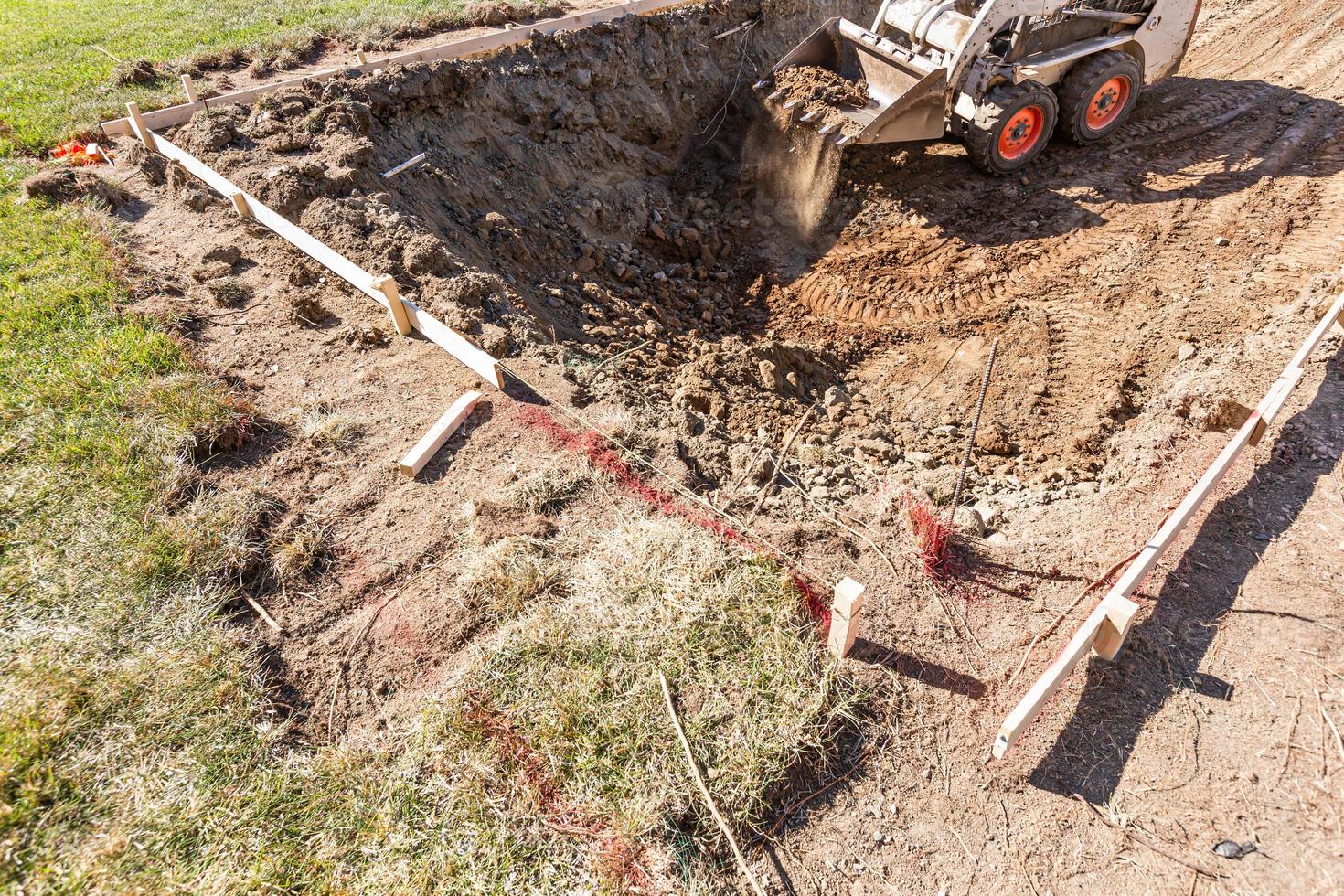 Small Bulldozer Digging In Yard For Pool Installation photo