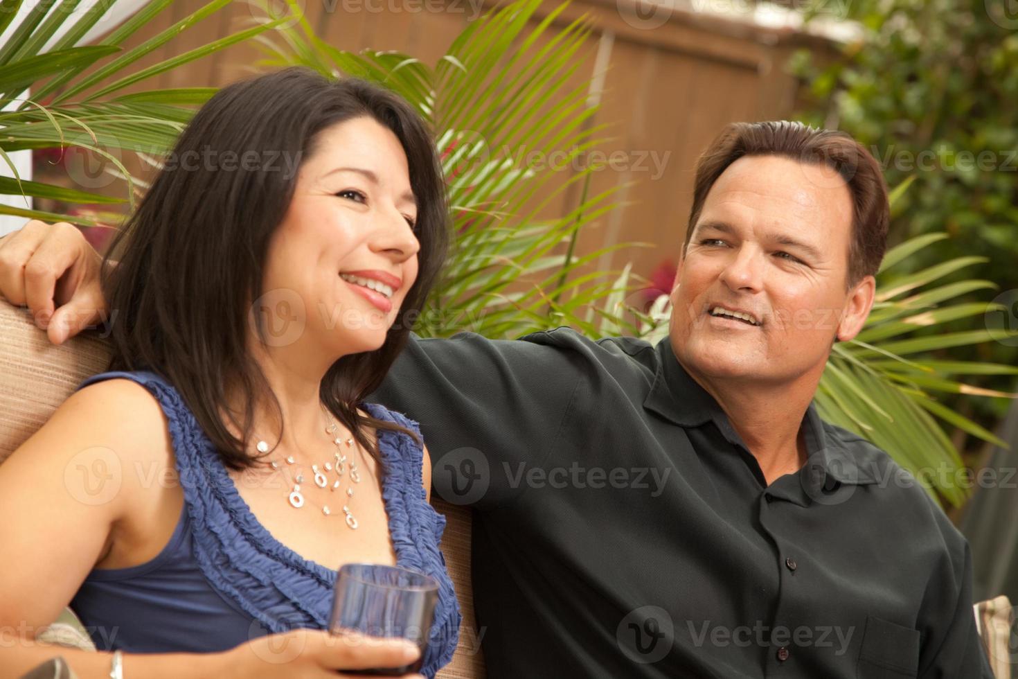 atractiva pareja hispana y caucásica bebiendo vino foto