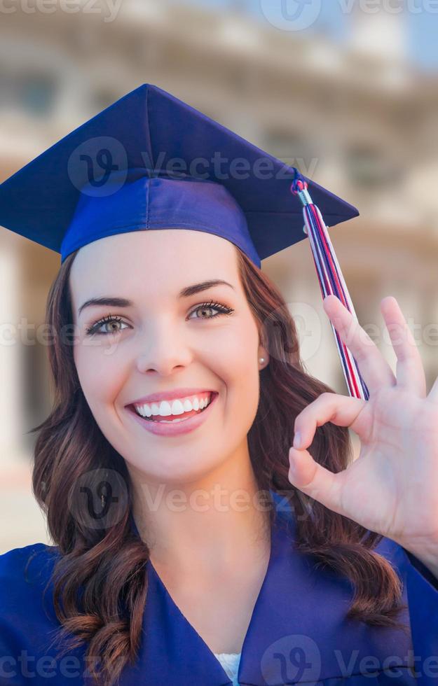 Happy Graduating Mixed Race Woman In Cap and Gown Celebrating on Campus. photo