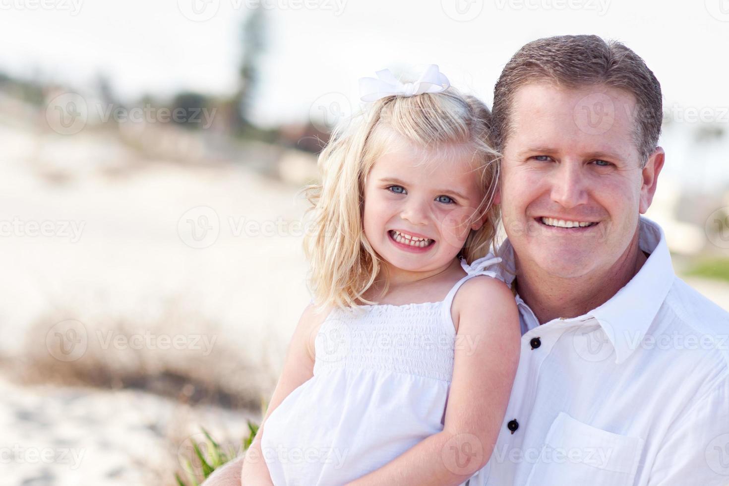 Cute Daughter Cuddles up with Her at the Beach photo