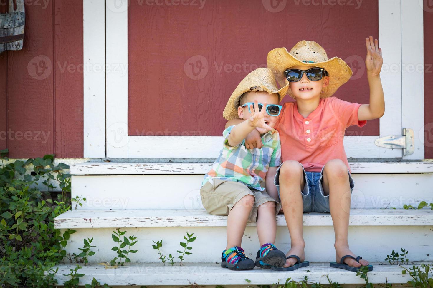 Mixed Race Chinese and Caucasian Young Brothers Having Fun Wearing Sunglasses and Cowboy Hats photo