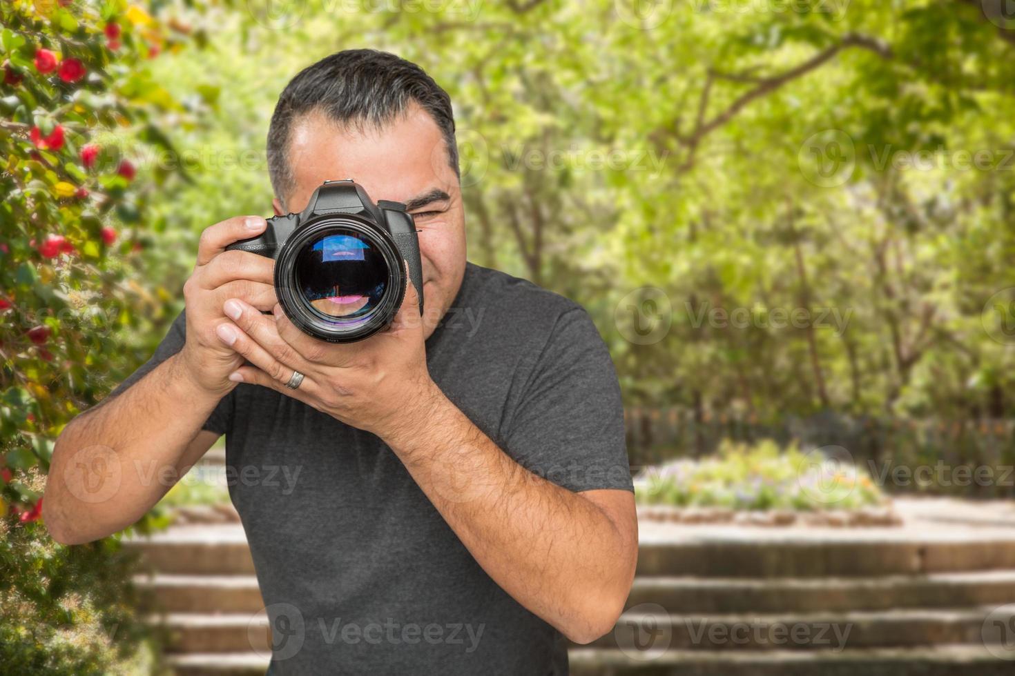 joven fotógrafo hispano con cámara dslr al aire libre foto