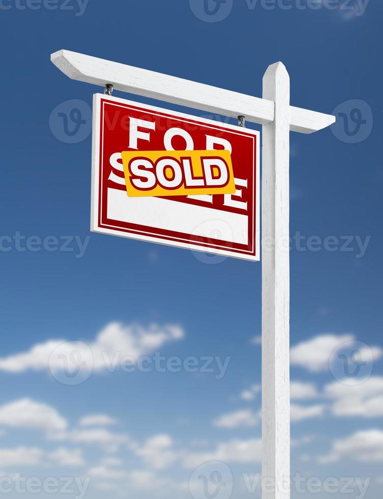 Left Facing Sold For Sale Real Estate Sign on a Blue Sky with Clouds. photo