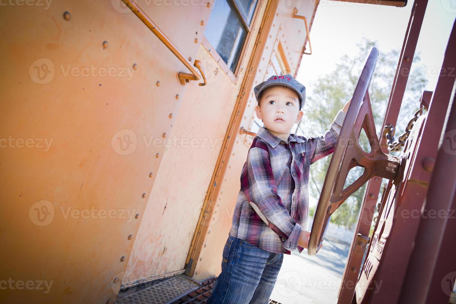 Cute Young Mixed Race Boy Having Fun on Railroad Car photo