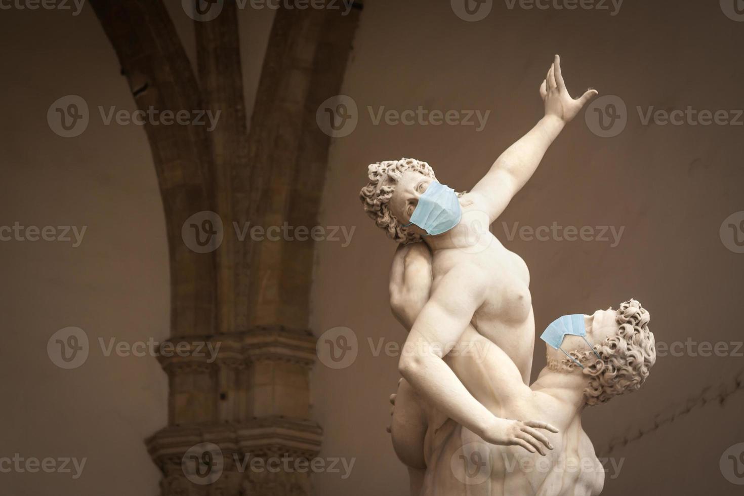 The Kidnapping of the Sabine Women Statue by Giambologna, in the Loggia dei Lanzi in Florence Italy With Face Masks - Coronavirus Scare photo