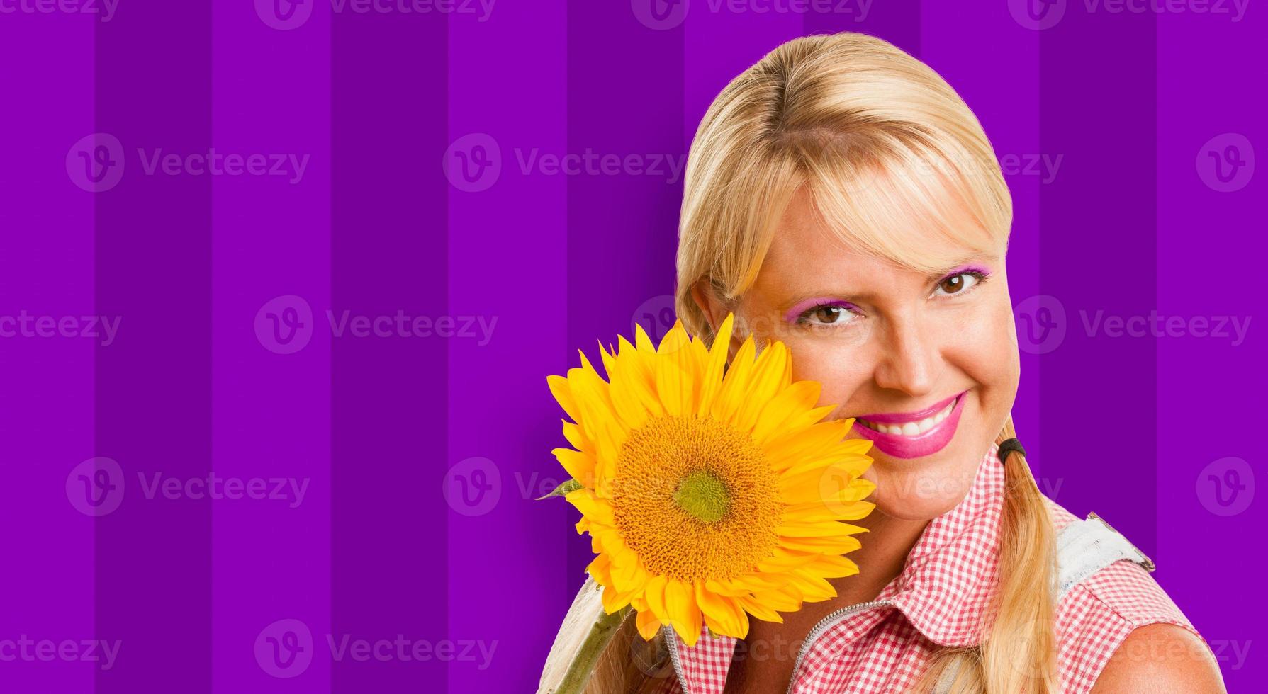 Beautiful Girl Holding Yellow Sunflower Against Purple Striped Background photo