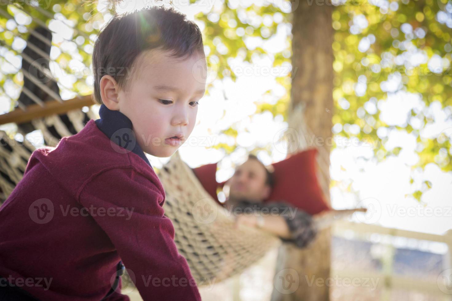 Mixed Race Boy Having Fun While Parent Watches From Behind photo