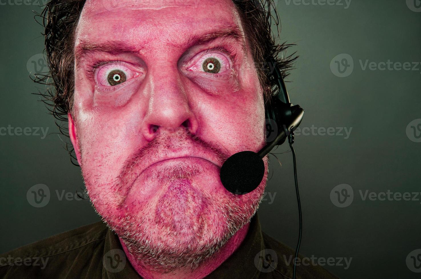 Grumpy Red Eyes and Face Customer Support Man with Headset photo