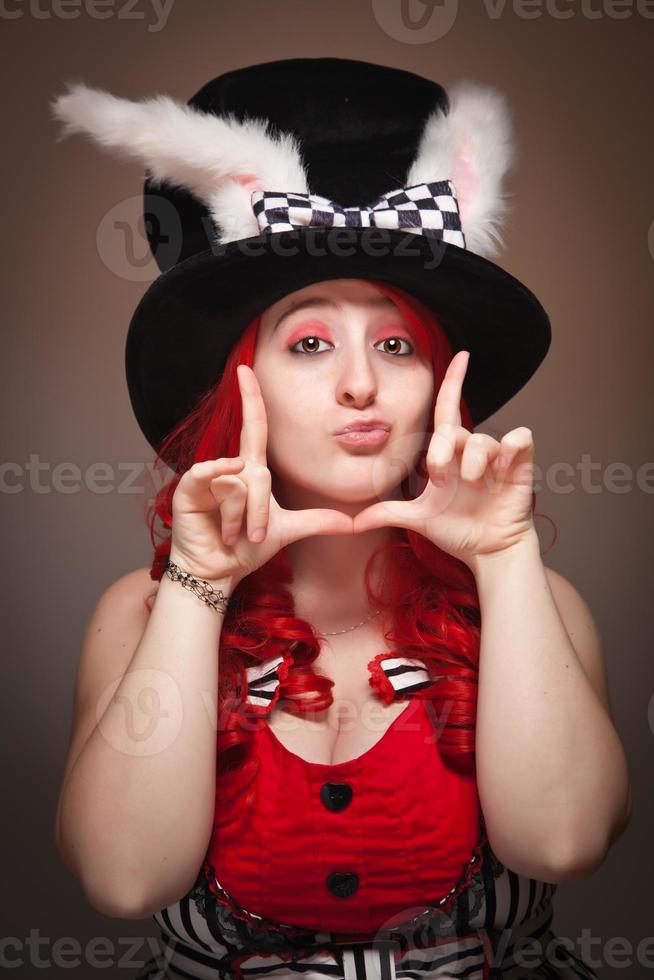 Attractive Red Haired Woman Wearing Bunny Ear Hat Framing Face photo