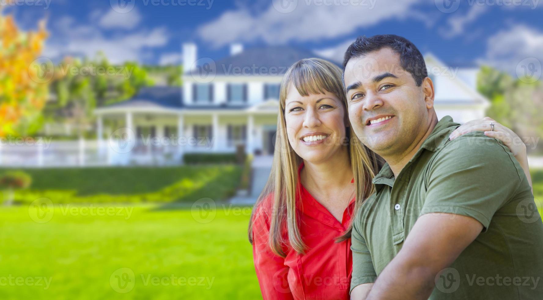 feliz pareja de raza mixta en frente de la casa foto